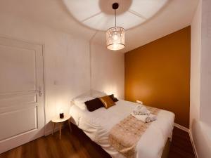 a small bedroom with a white bed and a lamp at Le Golden in Vierzon