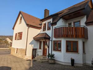 uma casa branca com uma varanda em cima em Landhaus an den Weinbergen em Pfaffenweiler