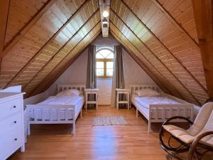 um quarto no sótão com 2 camas e uma janela em Landhaus an den Weinbergen em Pfaffenweiler