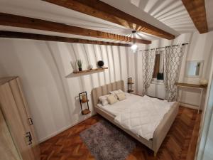 a bedroom with a white bed and a window at Middle Apartments in Braşov