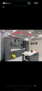 uma cozinha com armários de aço inoxidável e um balcão branco em استراحة وشاليهات عزيزه em Al Wajh
