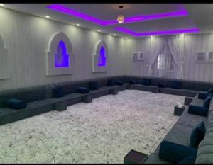 a room with couches and purple lights in a church at استراحة وشاليهات عزيزه in Al Wajh