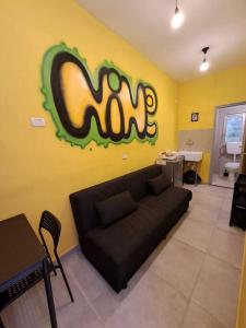 ein Wohnzimmer mit einem Sofa und einer Wand mit einem m-Schild in der Unterkunft Fellini Nine ground (talpiot) in Haifa