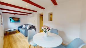 ein Wohnzimmer mit einem weißen Tisch und blauen Stühlen in der Unterkunft Résidence de l'ancien relais in Colmar
