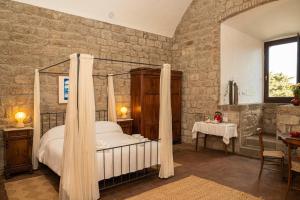 a bedroom with a canopy bed and a table at Torre dei Belforti in Montecatini Val di Cecina