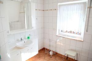 un bagno bianco con lavandino e finestra di Ferienwohnung und Pension Jentsch a Markische Heide