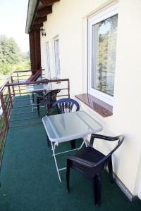un tavolo e sedie sul portico di una casa di Ferienwohnung und Pension Jentsch a Markische Heide