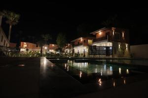 una casa con piscina di notte di PALM PARADISE Beach Resort a Pondicherry
