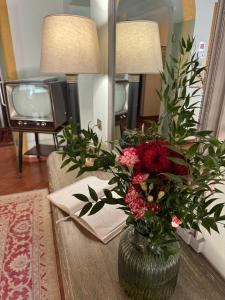 un vase avec des fleurs sur une table dans un salon dans l'établissement Cortona Resort & Spa, à Cortone 83 autres photos