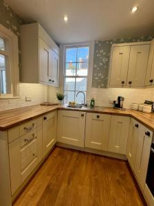 a kitchen with white cabinets and a sink and a window at City Chester Entire House Central in Chester