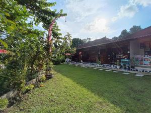 a garden in front of a building with a grass yard at Gosela Homestay in Munduk