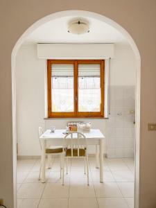 a kitchen with a table and two chairs and a window at La casa di Lory in Falconara Marittima