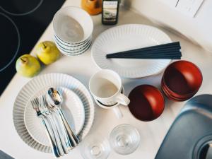 una mesa con platos y utensilios blancos. en MIMARU TOKYO UENO INARICHO, en Tokio