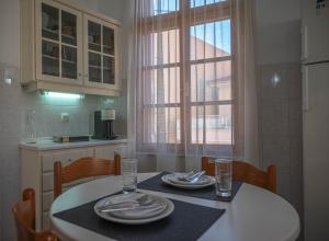 uma cozinha com uma mesa com pratos e copos em Panellinion Thassos em Limenaria