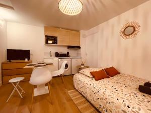 1 dormitorio con cama, escritorio y cocina en Le Wild Terracotta - Centre historique - Wifi et TV connectée - Stationnement à proximité en Niort