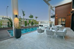 een patio met stoelen, een tafel en een zwembad bij Villa Six Eilat in Eilat