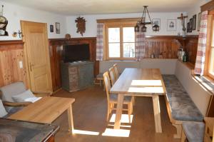 a dining room with a wooden table and a television at Ferienhaus Bognerhof in Sankt Veit im Pongau