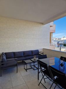Una sala de estar con un sofá y mesas. en Dimora Carmela, en Torre Santa Sabina