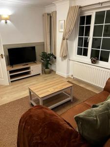a living room with a couch and a tv at Malham Wellbeing 5-bed Retreat With Hot Tub in Malham
