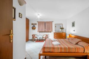 a bedroom with a bed and a dining room at Cherry House with Pool, Solarium Area and Barbecue in Manerba del Garda