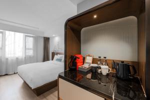 a hotel room with a bed and a vanity with a counter at UrCove by HYATT Beijing Forbidden City in Beijing