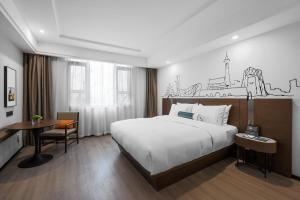 Pokój hotelowy z łóżkiem, biurkiem i biurkiem w obiekcie UrCove by HYATT Beijing Forbidden City w Pekinie