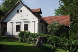une maison blanche avec un toit rouge dans l'établissement Creekside country cottage Nagyvisnyo/ Patakparti paraszthaz Nagyvisnyo, à Nagyvisnyó