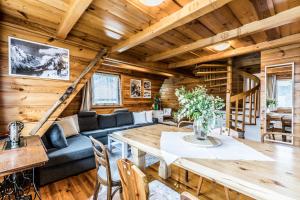 a dining room and living room in a log cabin at Apartament Nosalowy in Zakopane