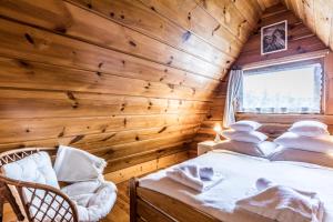 a log cabin bedroom with a bed and a window at Apartament Nosalowy in Zakopane