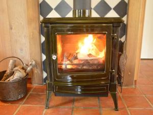a stove with a fire in it in a room at Pleasant Holiday Home near the centre of Haaren in Haaren