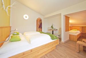 a bedroom with a large white bed with green pillows at Hotel Garni Landhaus Gitti in Zell am See
