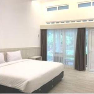 - une chambre avec un lit et une grande fenêtre dans l'établissement Tambi Tea Resort, à Kejajar