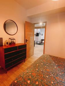 a bedroom with a bed and a dresser and a mirror at Lisloft Appartement à 5 Min du ZooParc de Beauval, Centre ville Saint-Aignan in Saint-Aignan