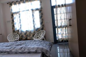 1 dormitorio con 1 cama, 2 sillas y ventana en Vista Solan, en Solan