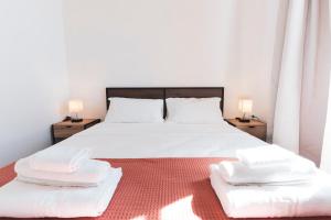 una camera da letto con un grande letto bianco con due comodini di Villa Nonno Alfonso a Marina di Camerota