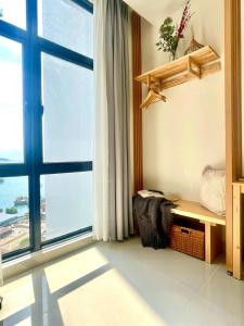 a room with a large window and a bench with a view at Cozy Ocean View APT in KK City Center in Kota Kinabalu