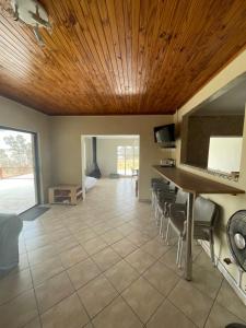 a living room with a wooden ceiling at Vaaldam @ Sgt Pepper’s Holiday Home in Oranjeville