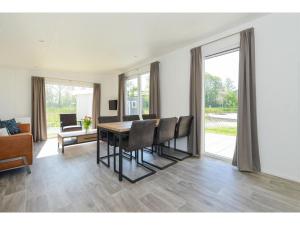 uma sala de estar com uma mesa de jantar e cadeiras em Brand new chalets at 10 minutes from the Oosterschelde em heinkenszand