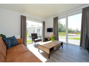 uma sala de estar com um sofá e uma mesa em Brand new chalets at 10 minutes from the Oosterschelde em heinkenszand