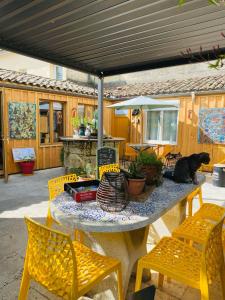 een tafel met stoelen en een kat erop bij Les Chambres d'Ovaline in Saint-Émilion