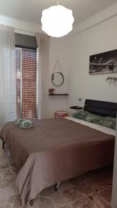 ロッカルメーラにあるCASA VACANZA ROCCALUMERA (ME)の大きなベッドと大きな窓のある寝室