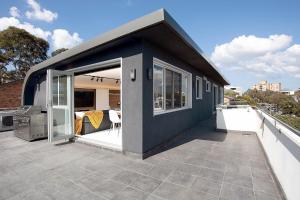 een klein huis op een dak met een patio bij Perfect Located 2-Bed with Spacious Balcony & BBQ in Sydney