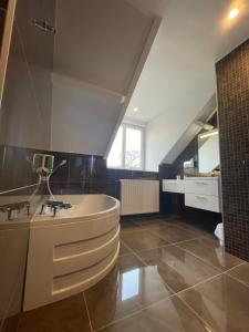 een grote badkamer met een bad en een wastafel bij Hotel Le Cercle in Cherbourg en Cotentin