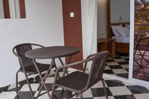 a table and two chairs in a room with a bedroom at JIRAJIRA HOTEL in Nosy Be
