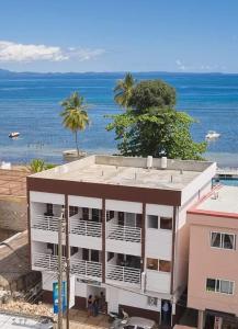 an apartment building with the ocean in the background at JIRAJIRA HOTEL in Nosy Be