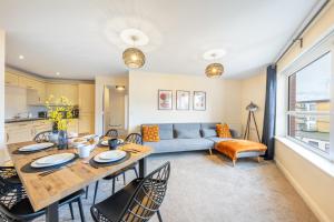 a kitchen and living room with a table and chairs at Business & Family Friendly Accommodation with FREE Private Gated Parking in Hatfield - Business Park, Hertfordshire University, Fast trains to London in Hatfield