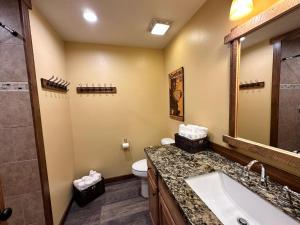 a bathroom with a sink and a toilet and a shower at Yellowstone Cabins and RV in West Yellowstone