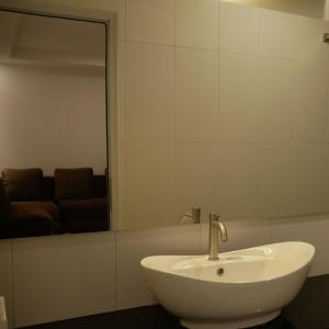 La salle de bains est pourvue d'un lavabo blanc et d'un miroir. dans l'établissement Tambi Tea Resort, à Kejajar