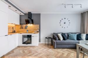 a living room with a couch and a kitchen at Beautiful Apartment with Balcony for 6 people in Cracow by Renters in Krakow