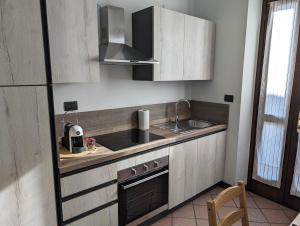eine kleine Küche mit einer Spüle und einem Herd in der Unterkunft Sentirsi a casa in Verzuolo